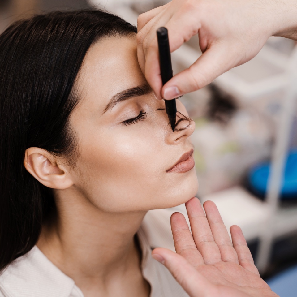 ENT doctor is drawing mark up lines on nose before rhinoplasty surgery. Rhinoplasty markup. Rhinoplasty is reshaping nose surgery for change appearance of the nose and improve breathing