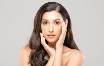 Beautiful Glamour indian woman touch cheek smile with clean and fresh skin Happiness and cheerful with positive emotional,isolate on grey background,Beauty Cosmetics and spa Facial treatment Concept
